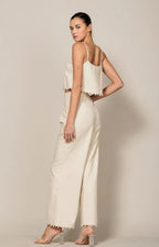 Model wearing a cream Shadow & Shine sleeveless crop top and wide leg trousers with pom-pom trim details.