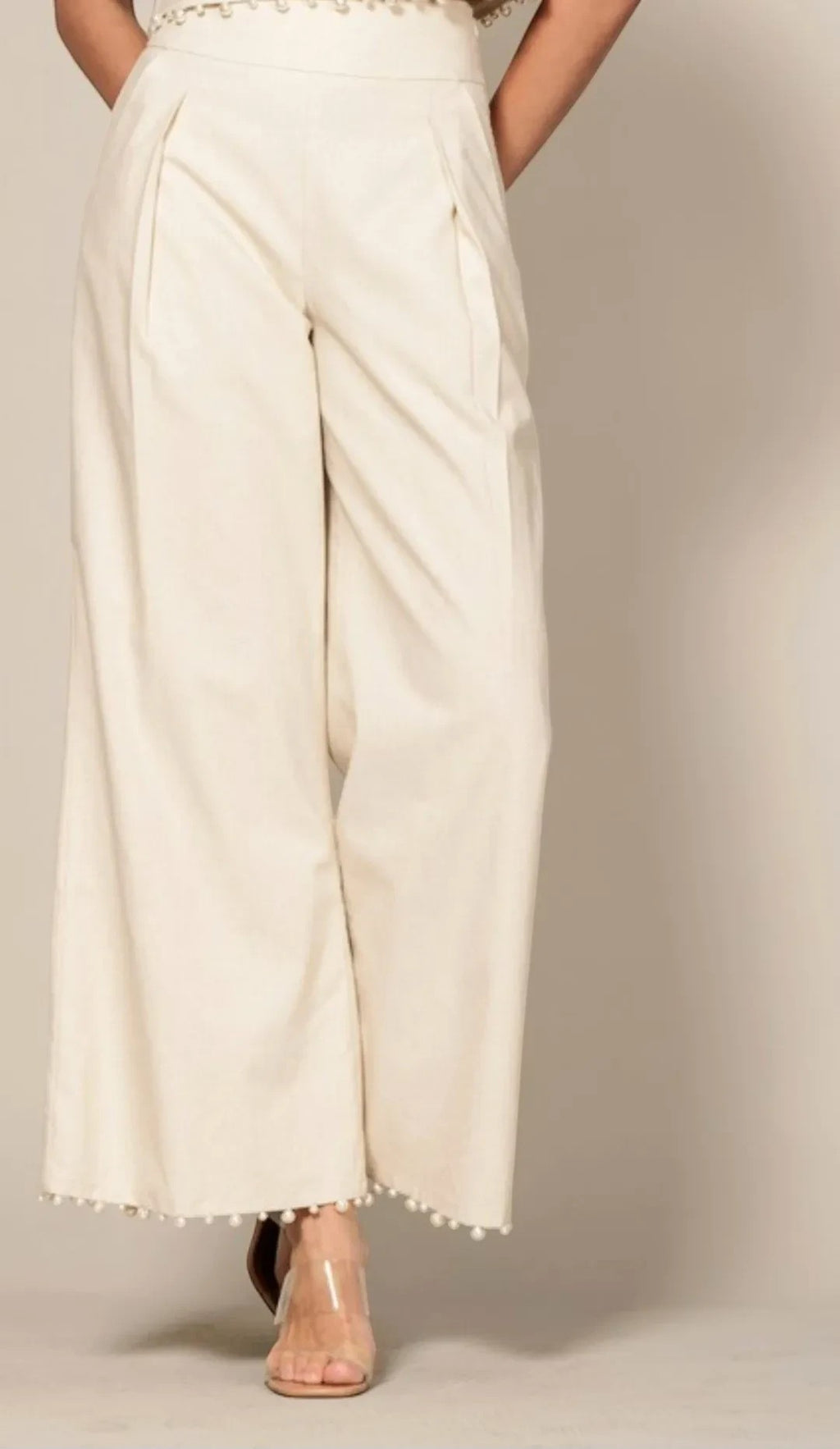 Shadow & Shine cream sleeveless crop top and wide-leg trouser set with delicate pom-pom trim hem detail.