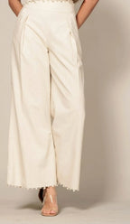 Shadow & Shine cream sleeveless crop top and wide-leg trouser set with delicate pom-pom trim hem detail.