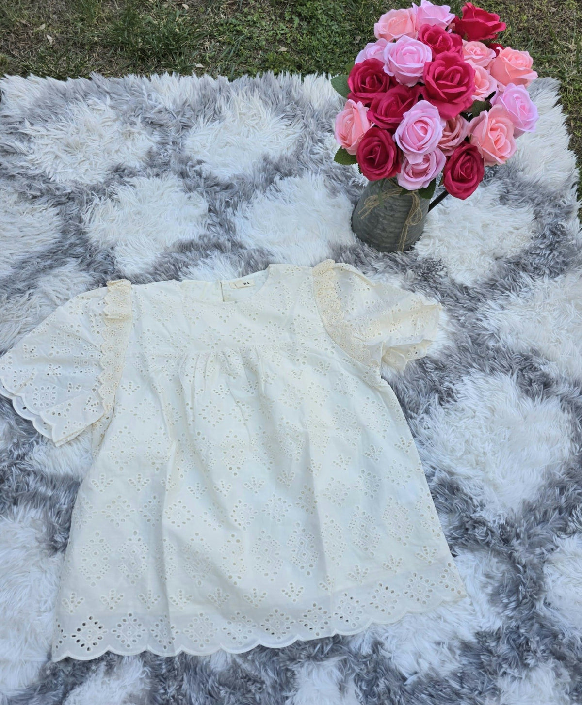 Shadow & Shine cream cotton eyelet puff sleeve blouse with floral cutwork and ruffled details.